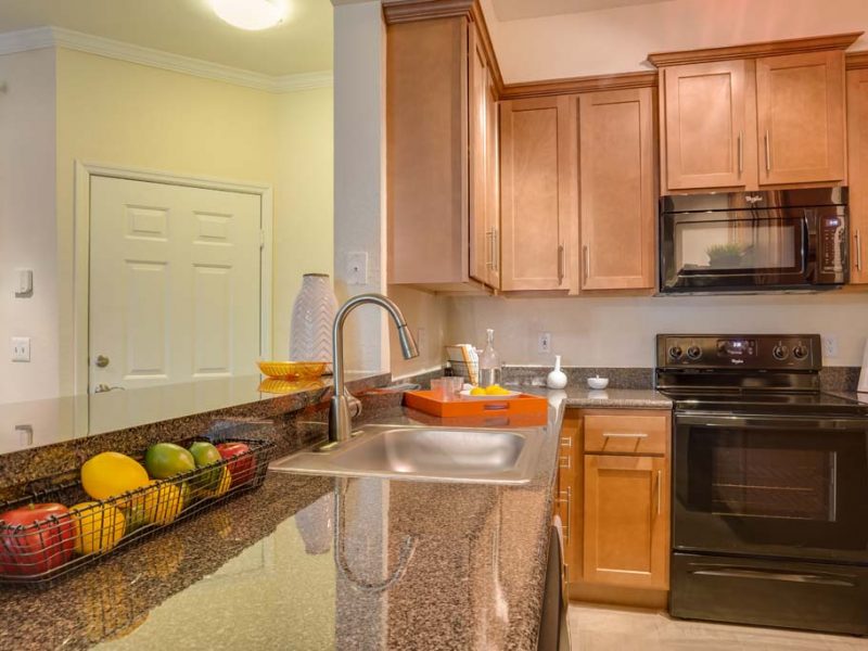 This image shows the fully equipped gourmet kitchen with a breakfast bar and granite-inspired countertops.